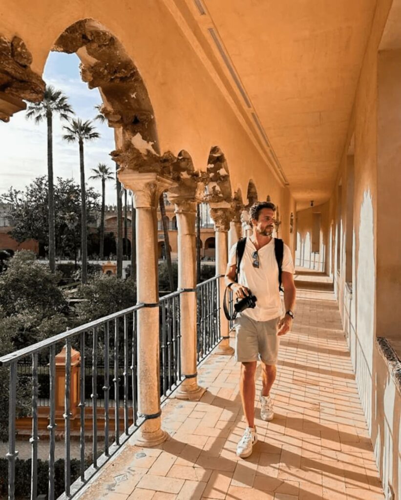 Fotógrafo Berlemes andando com uma câmera na mão, em Alcazar de Seville